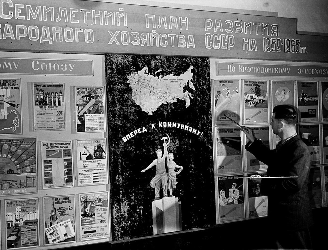 農業発展七ヶ年計画表のそばに立つコンバイン運転手の助手フョードル・フロロフ。ソフホーズ「クラスノドンスキー」文化会館。カザフスタン。1959年