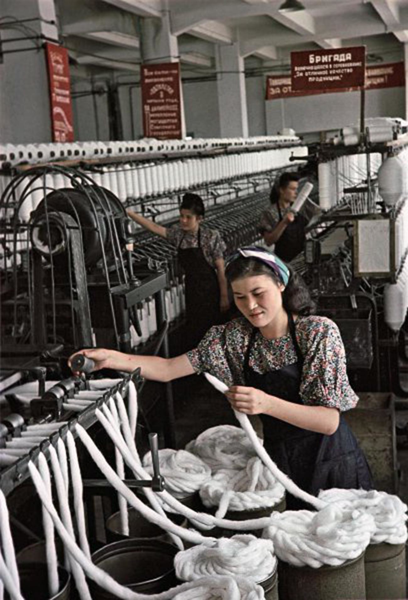 アルマトイ綿紡績工場準備部門の紐製造スタハノフ運動者、マリア・ナシリバエワ。彼女は孤児院の保母でもあった。班の友人らとともに、ノルマを200パーセント上回った。「オゴニョーク」誌アーカイブ。1950年。