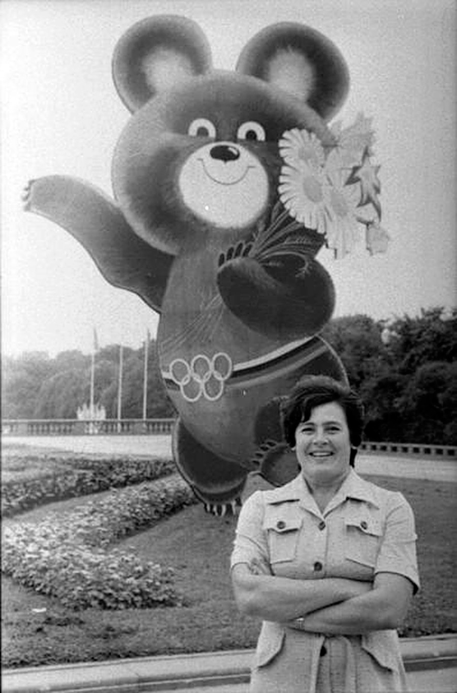 Portrait of a woman in front of Mishka, the mascot of the 1980 Moscow Olympics