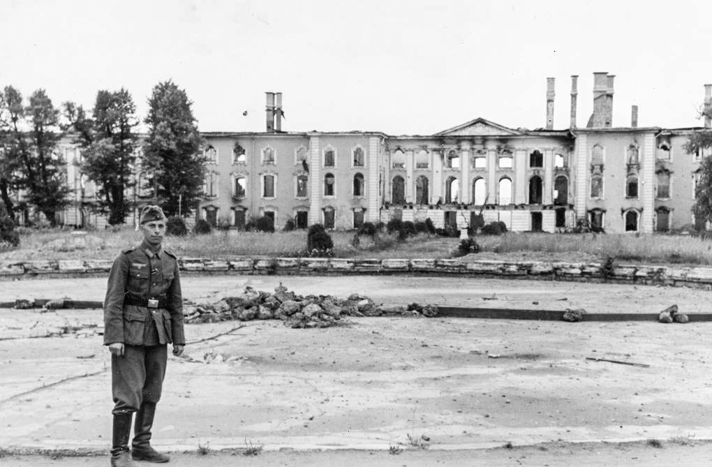 Ein deutscher Soldat posiert vor dem Großen Palast in Peterhof, 1943