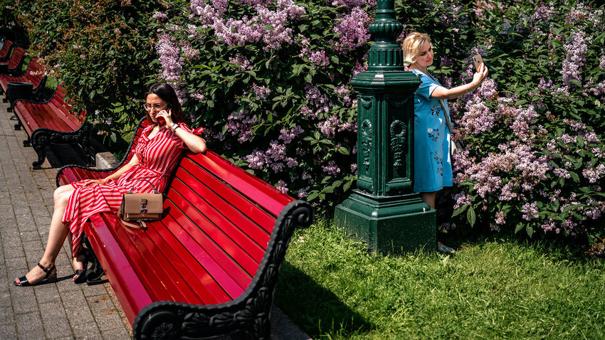 Ženske uživajo v toplem in sončnem dnevu v parku v centru Moskve, 9. junija 2020, prvi dan po tem, ko je Moskva odpravila vrsto omejitvenih ukrepov, vključno s strogo samoizolacijo, ki so jih vzpostavili za zaustavitev širjenja bolezni COVID-19, ki jo je povzročil novi koronavirus.