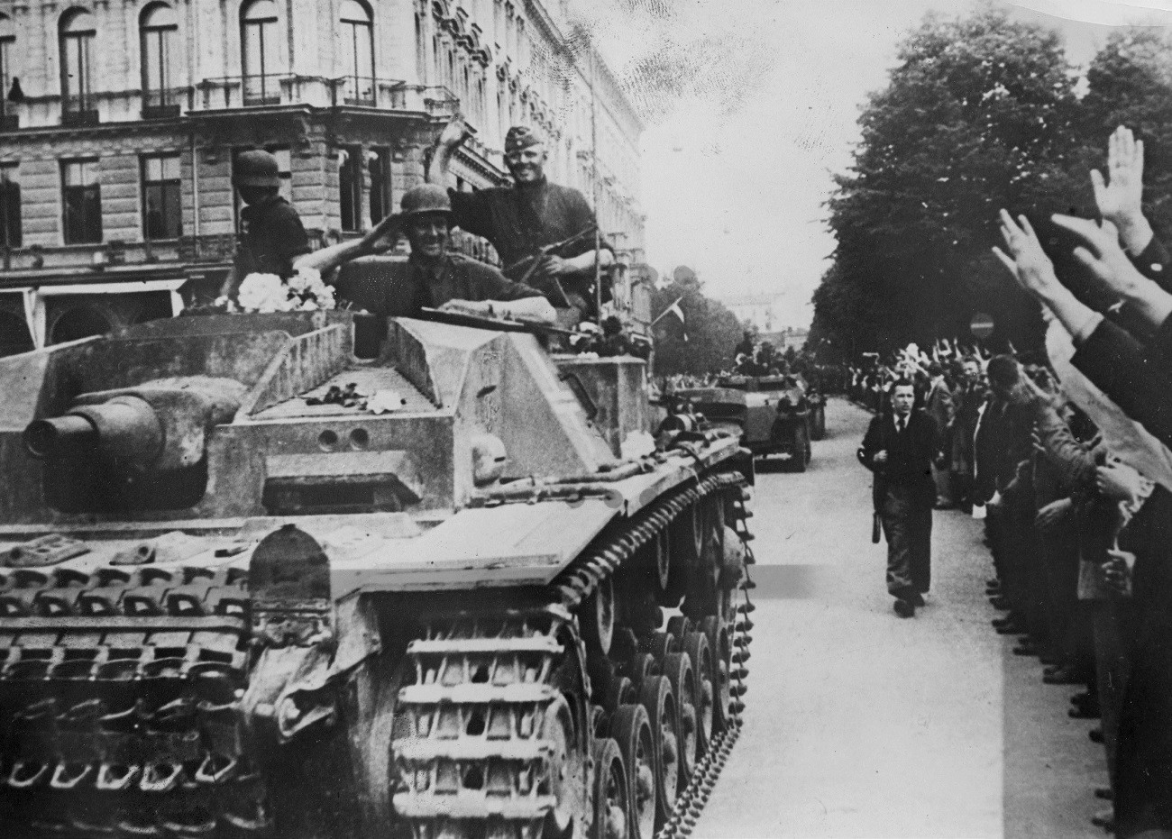 Deutsche Soldaten werden von Einheimischen begrüßt, als sie im Juli 1941 in das sowjetische Riga einmarschieren.