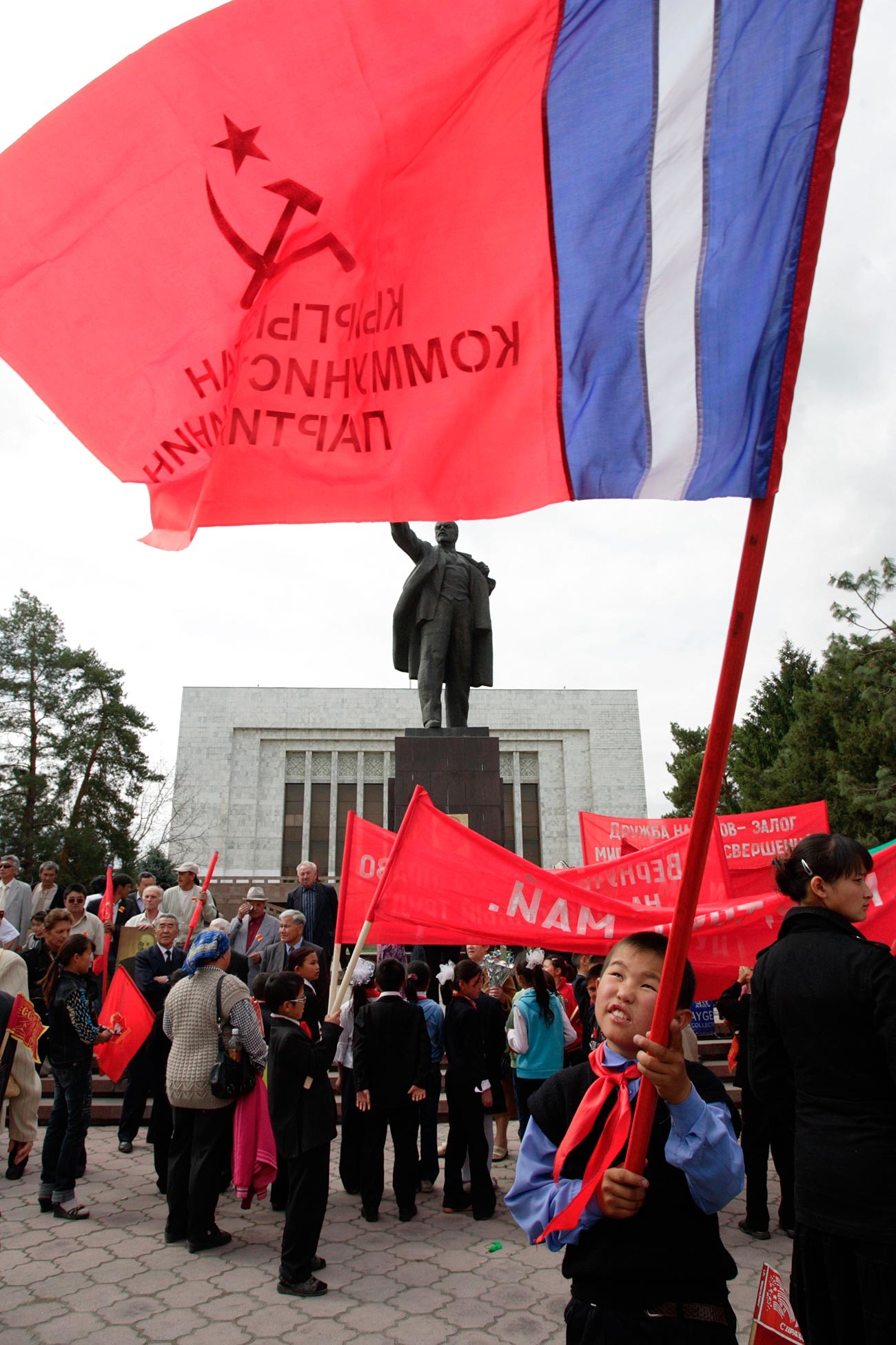 Seorang anak laki-laki mengibarkan bendera komunis selama perayaan Hari Buruh Internasional di Bishkek.