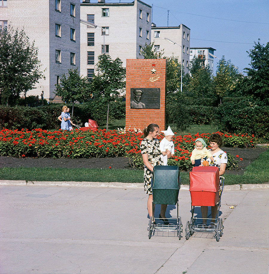 De jeunes mères dans la ville de Novoloukoml avec, en fond, le monument au commandant de détachement de partisans Fiodor Ozmitel, 1978

