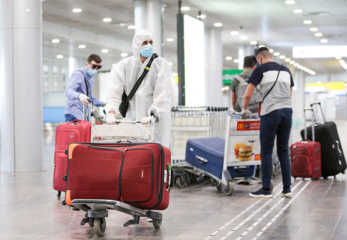 People who have arrived from New York City on an Aeroflot - Russian Airlines flight, carry their luggage at the arrivals area of Sheremetyevo International Airport. June 17.2020