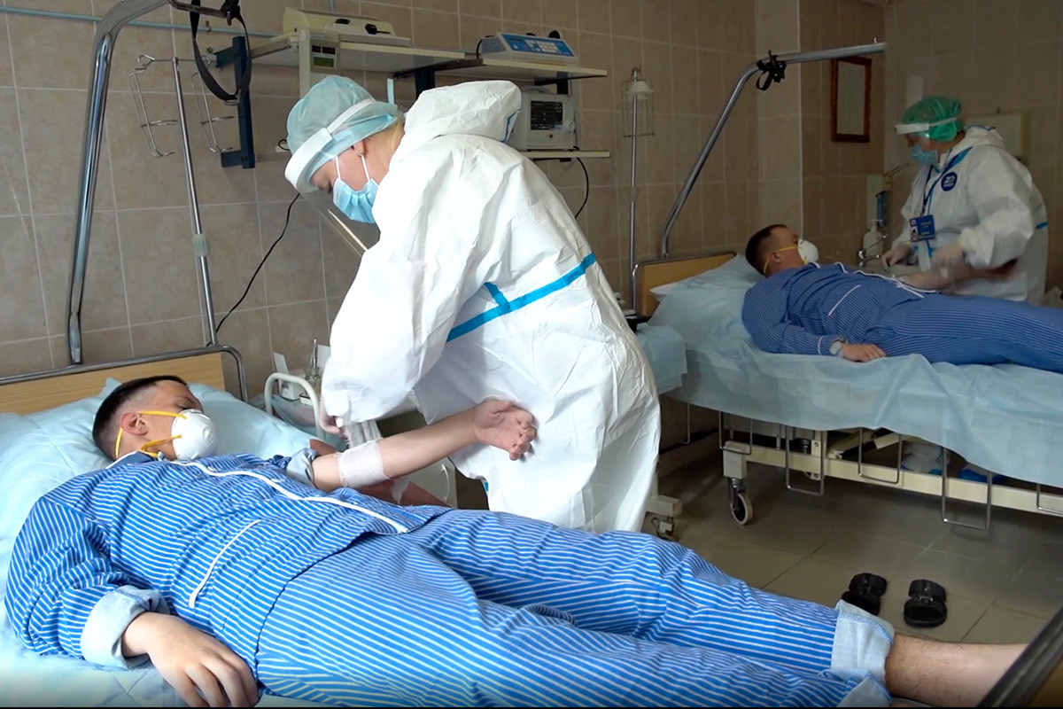 Кадърът от видеото, пуснато от министерството на отбраната на Русия на 15 юли 2020 година. Медицински работници в предпазна екипировка се подготвят за вземане на кръв от доброволци, които участват в изпитанията на ваксината срещу коронавирус в Главната военна болница 