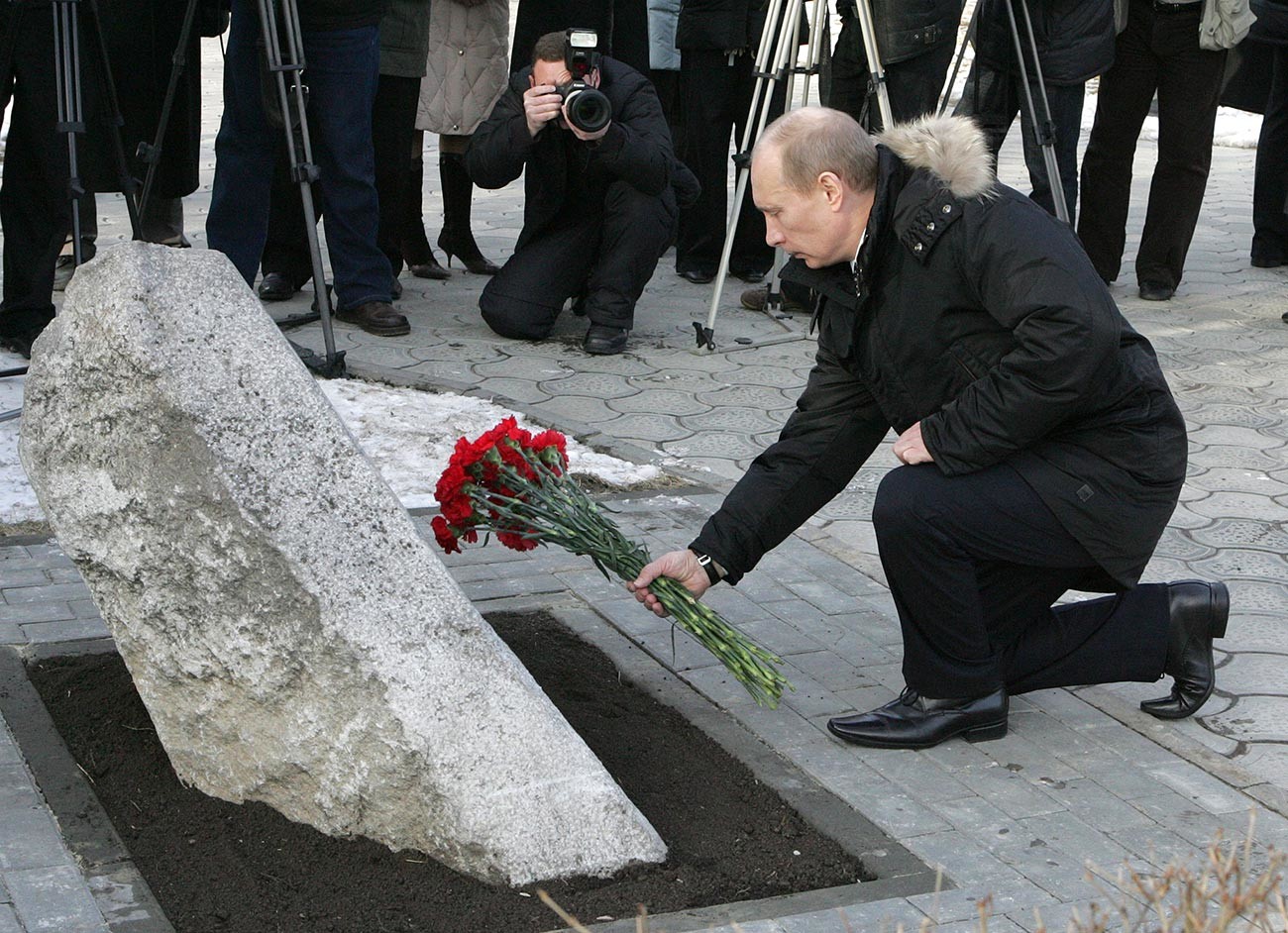Vladimir Poutine déposant des fleurs devant la stèle commémorant les événements de 1962