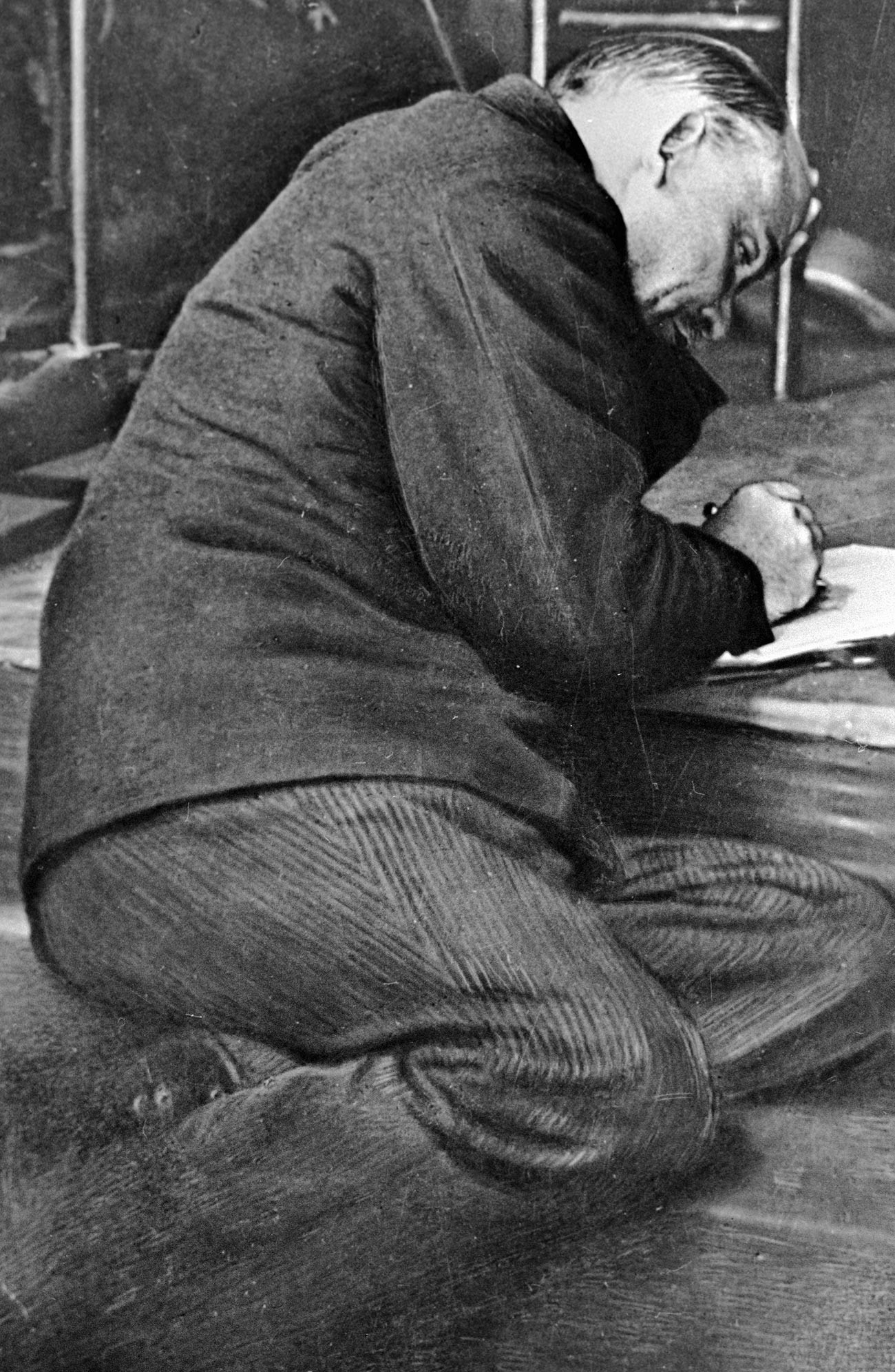 В. И. Ленин пише нещо на стъпалата на трибуна по време на заседанието на III конгрес на Коминтерна в Андреевската зала в Кремъл.