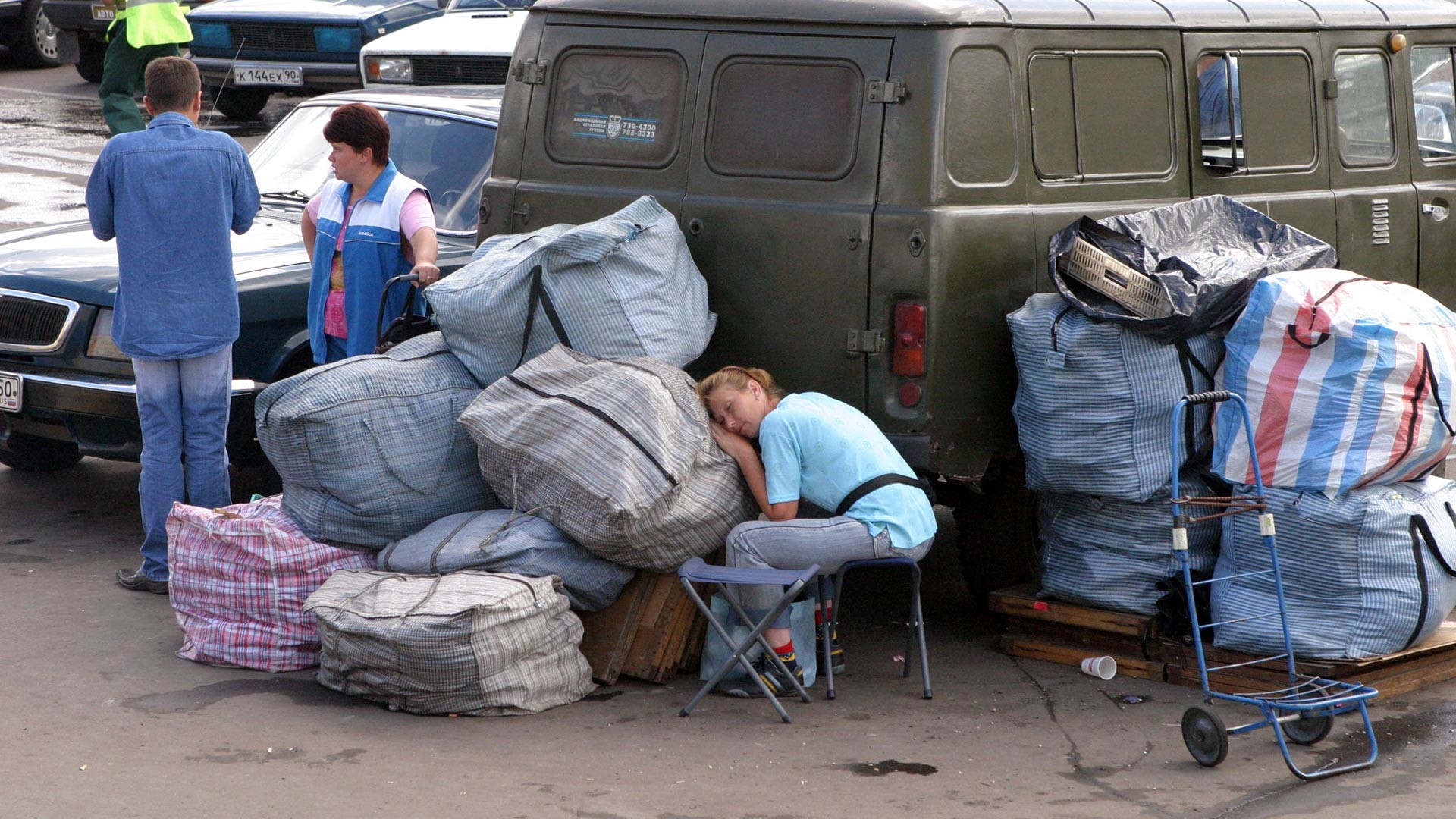 Люди с багажом на Комсомольской площади в Москве. Начало 2000-х.