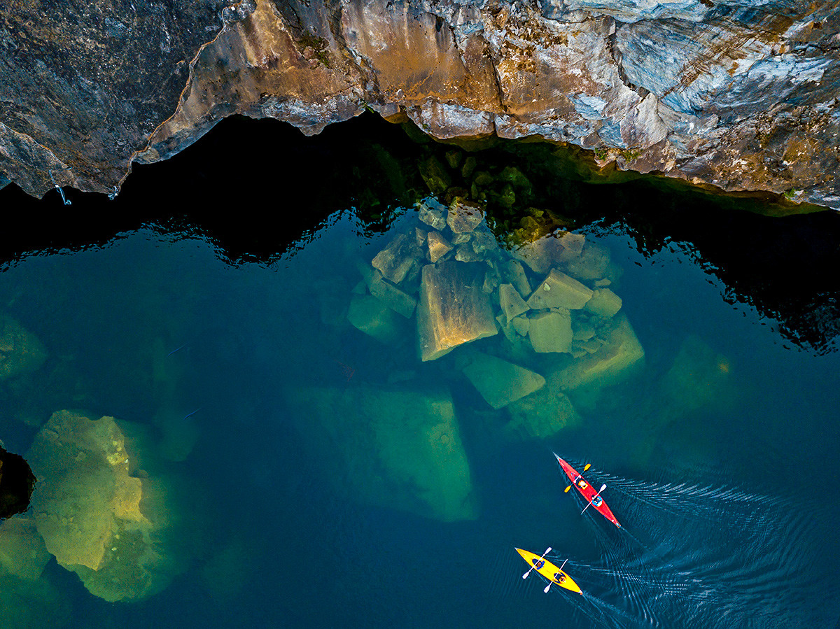Kayakers sailing over sunken boulders in Lake Light.