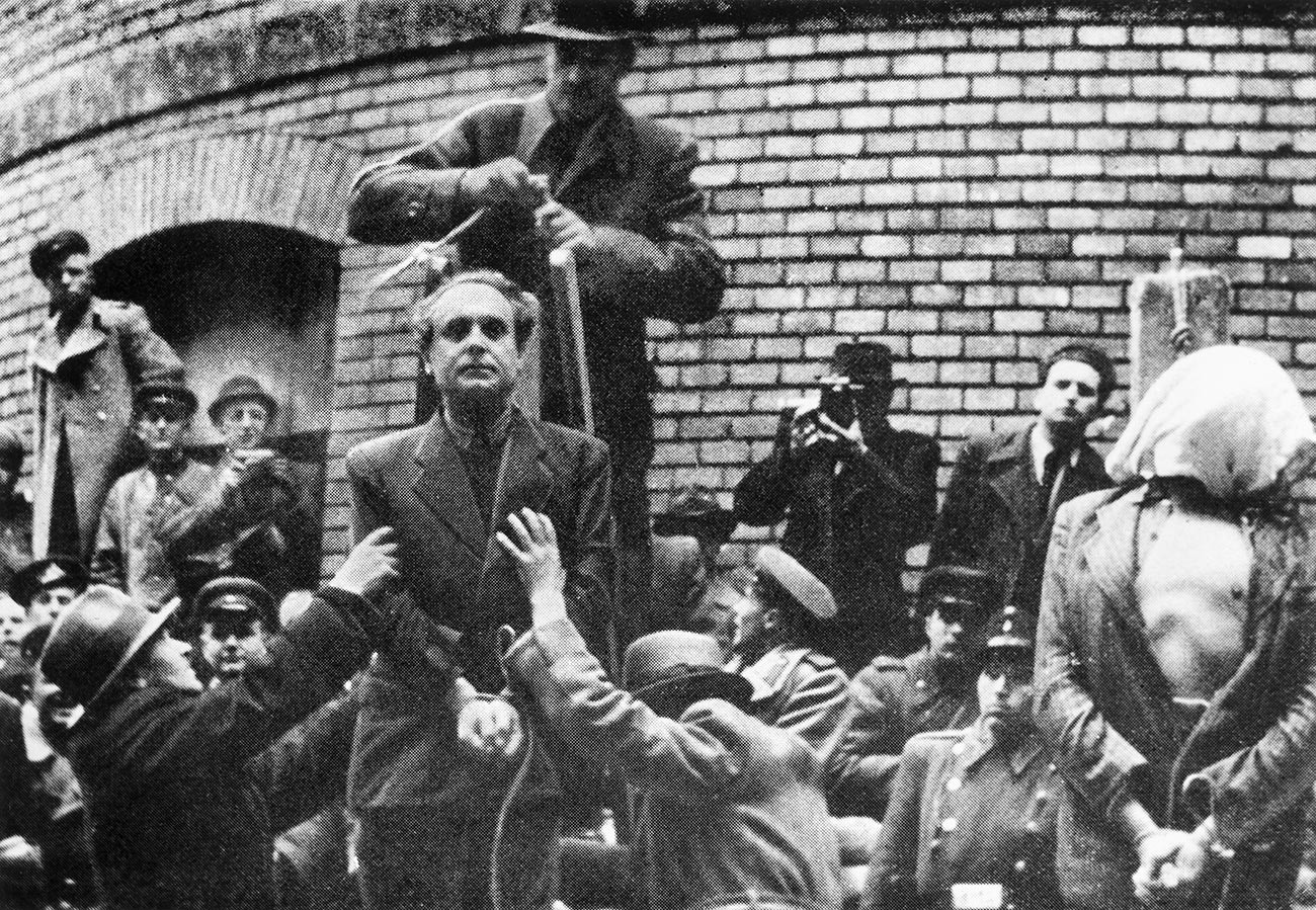 Унгарският нацистки лидер Ференц Салаши стои до екзекутиран човек със завързани ръце, чувал на главата и разкопчана риза, докато мъж зад Салаши подготвя примката за публичното му обесване, Унгария, 1946 г.