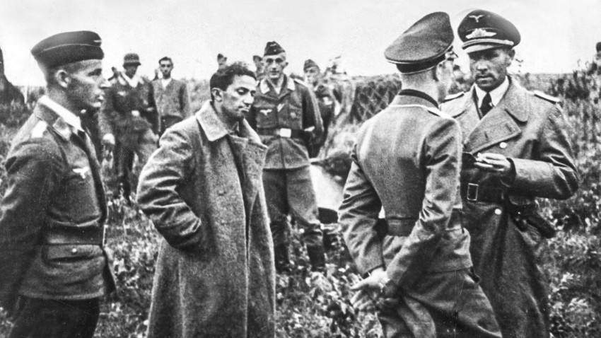 El primer hijo de Josef Stalin, Yákov Dzhugashvili espera a ser llevado a la retaguardia para ser interrogado. A su alrededor, oficiales de la Luftwaffe