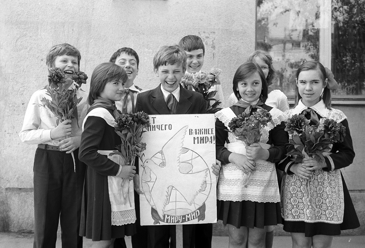 Skupina otrok, ki drži plakat, na katerem piše: 