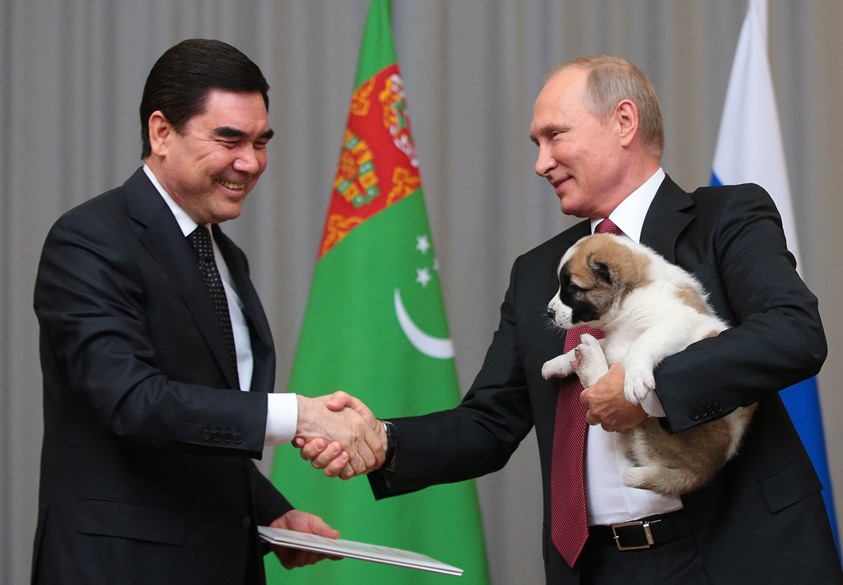 Turkmenistan's President Gurbanguly Berdimuhamedow (L) and Russia's President Vladimir Putin shake hands during a meeting at a conference centre of the Radisson Blu Resort hotel