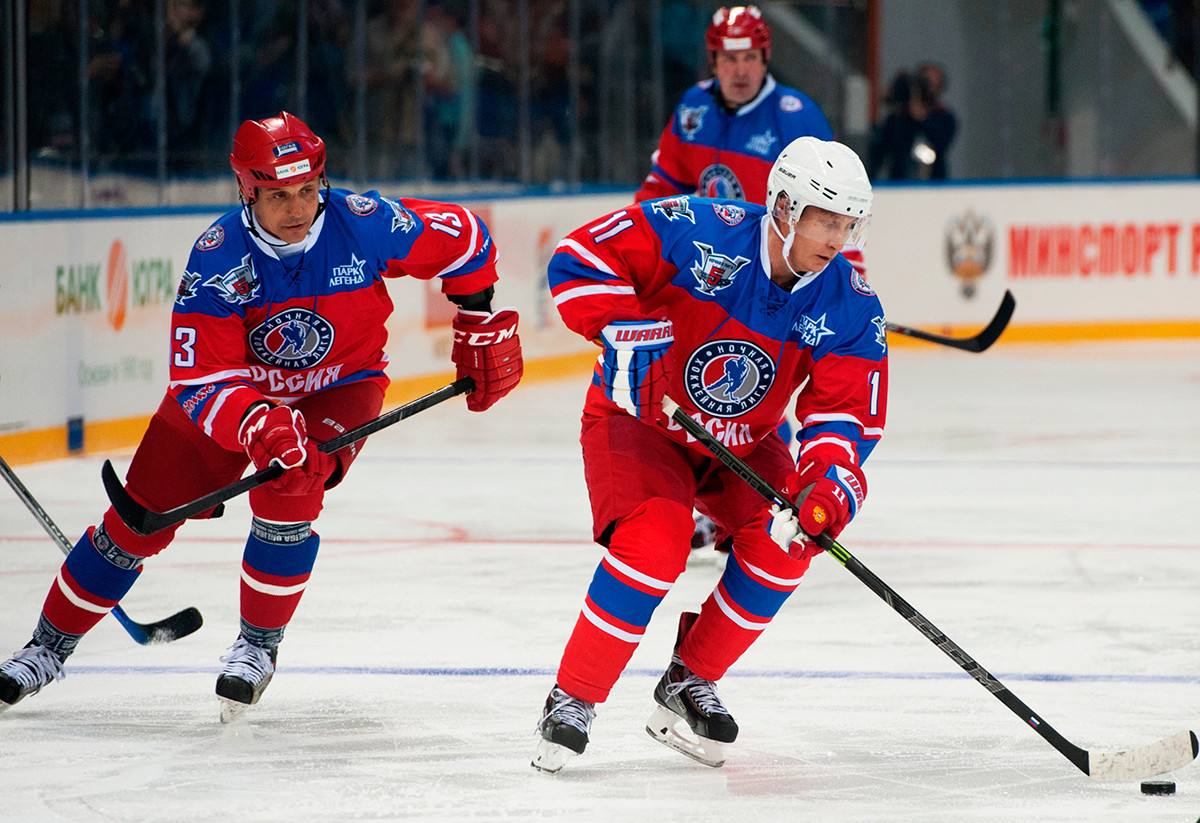Presiden Rusia Vladimir Putin (kanan) dan kurator konferensi Volgaskaya Oblast Valery Kamensky dalam pertandingan antara tim nasional 'Zvezdy' Liga Hoki Malam (NHL) dan tim nasional Dewan dan tamu kehormatan NHL.