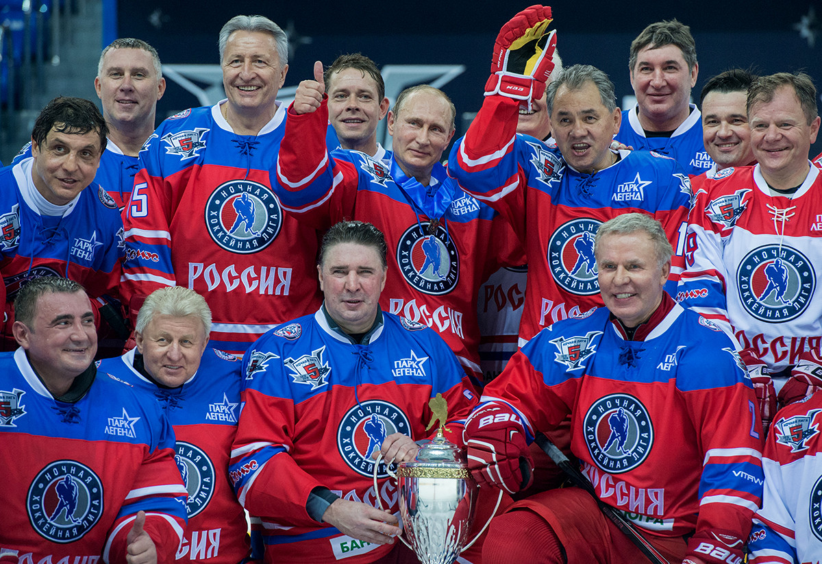 Presiden Rusia Vladimir Putin (mengacungkan jempol) berfoto bersama setelah pertandingan hoki.