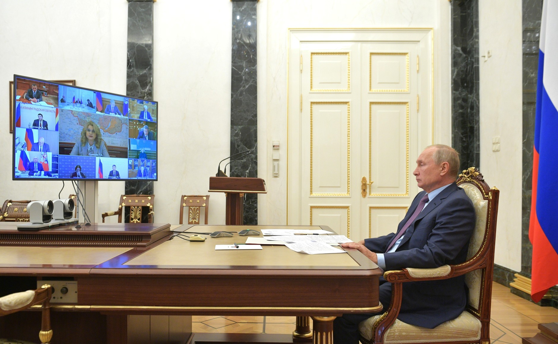 Presiden Rusia Vladimir Putin mendengarkan pemaparan Menurut Wakil Perdana Menteri Rusia Tatyana Golikova (pada layar utama), dalam rapat kabinet virtual, Moksow, Kamis (15/10).