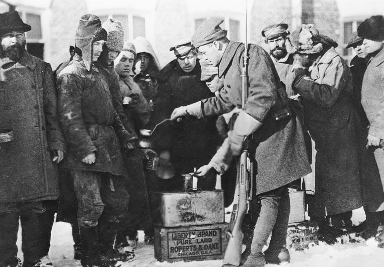 American soldiers distribute food to the prisoners.