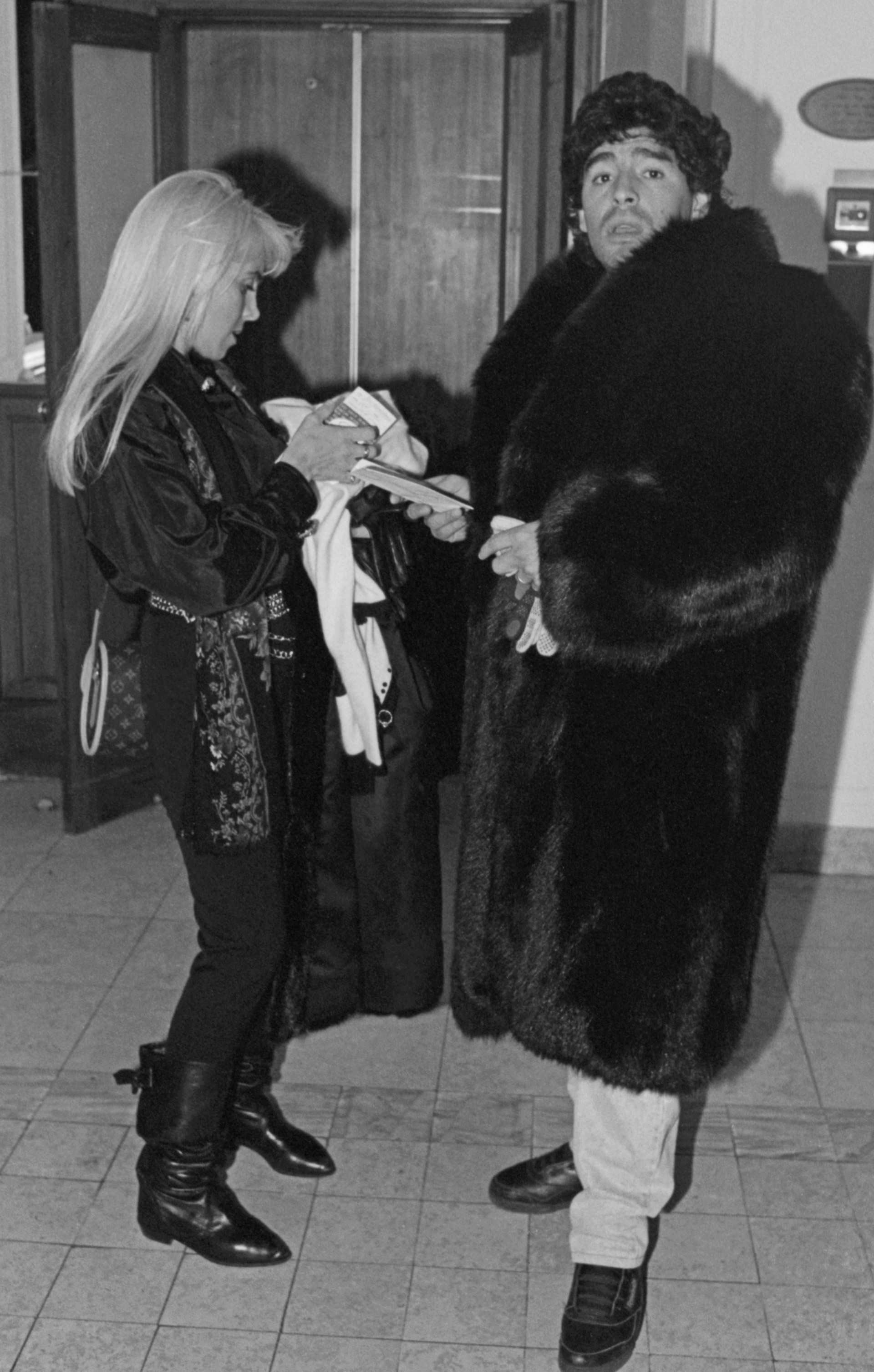 Maradona com casaco de pele no hall do Hotel Berlim, em Moscou, acompanhado da mulher Claudia Villafañe

