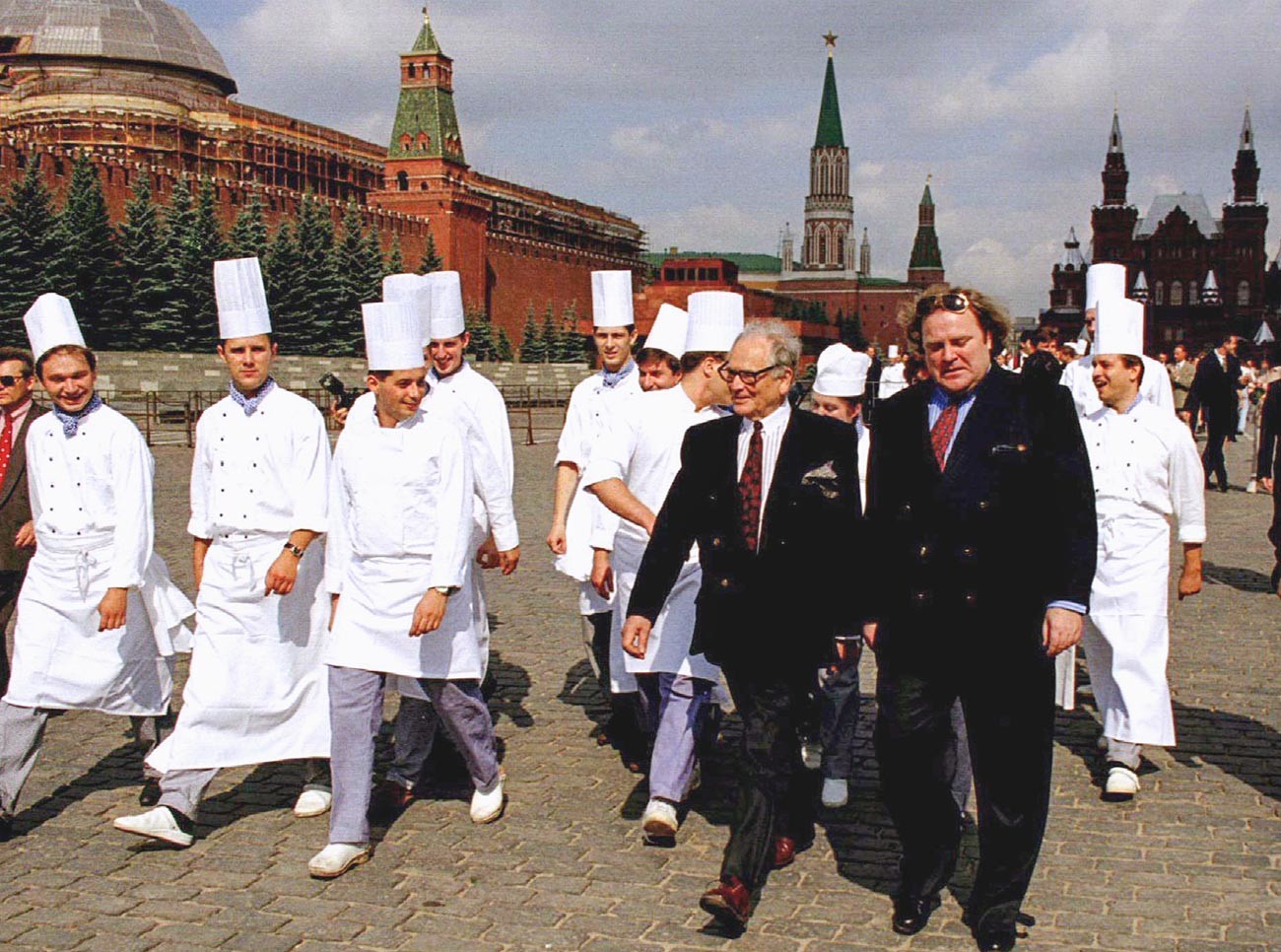Pierre Cardin accompagné de son assistant Jeff Knipper, ainsi que du personnel du Maxim's inauguré à Moscou, marchant sur la place Rouge