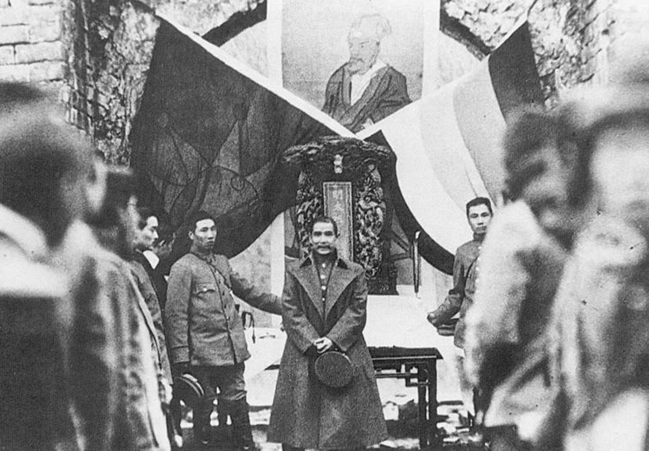 Кинеска (Синхајска) револуција, 1912. г. Сун Јат Сен под заставама „Пет раса у једној унији“ и „Плаво небо и бело сунце“.