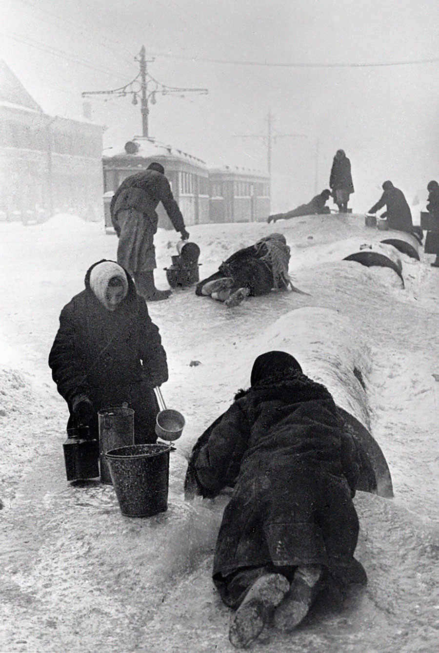 Les habitants de la ville de Leningrad remplissent leurs seaux depuis une conduite endommagée par une journée glaciale, janvier 1942.