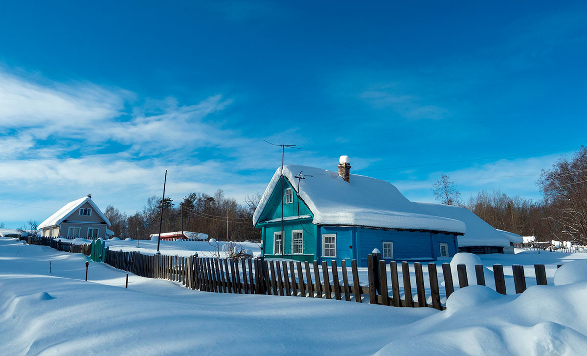 Holzhäuser im Schnee in dem karelischen Dorf Kokoila.