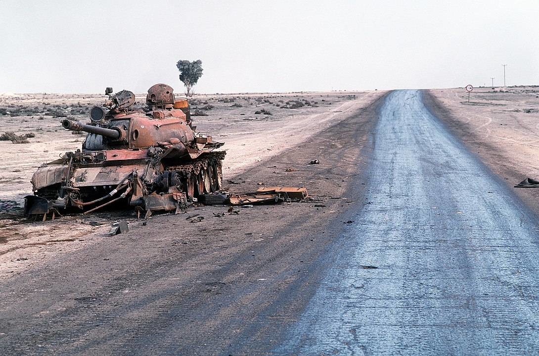 Un carro de combate iraquí T-55A destruido yace abandonado junto a una carretera al borde de un campo petrolífero tras la Operación Tormenta del Desierto.