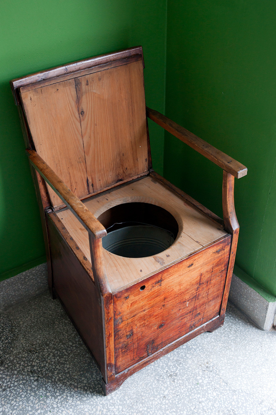Inodoro vintage hecho de sillón de madera y cubo.
