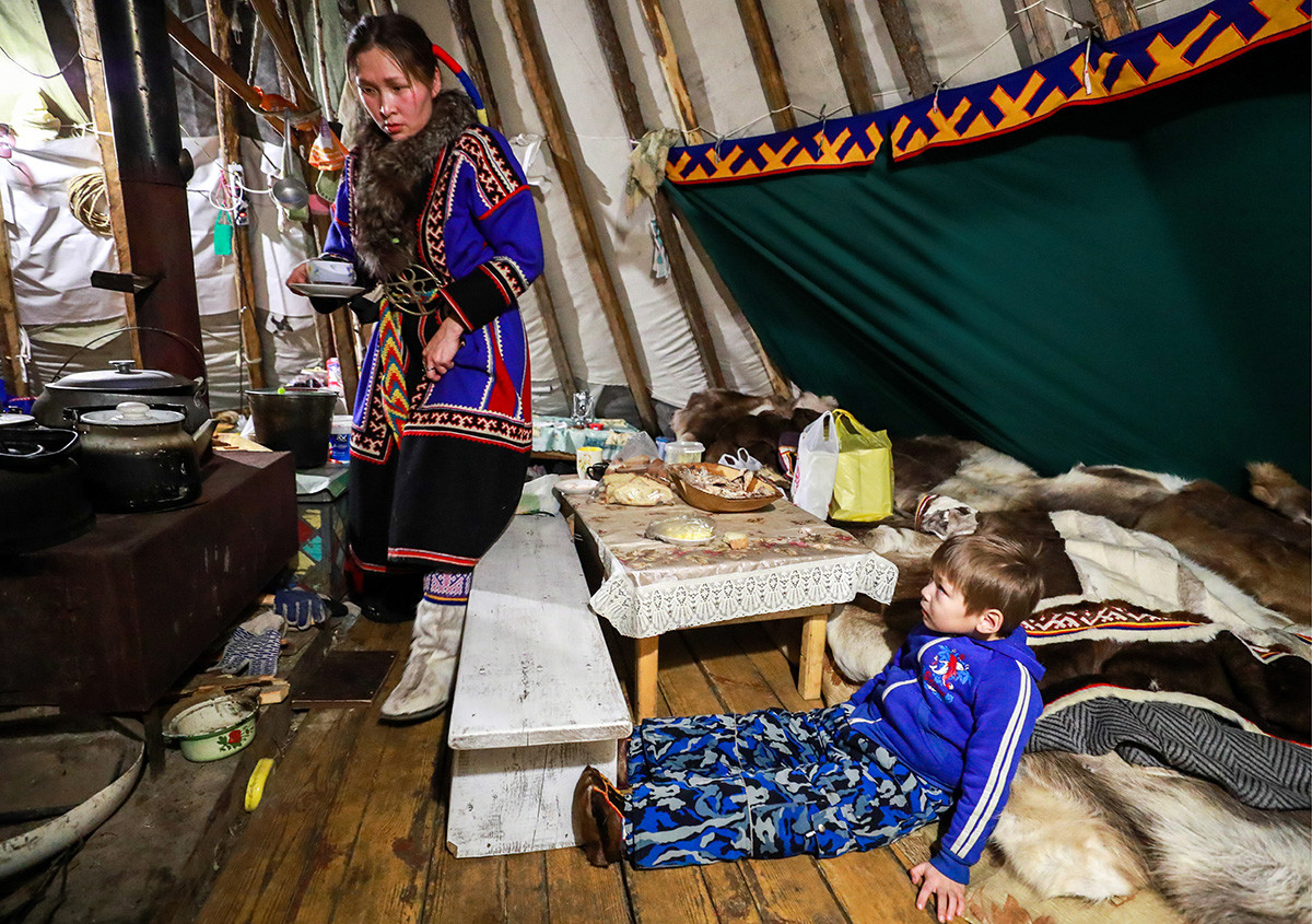 Un ayudante del cuidador de un chum prepara el desayuno en el pueblo de Gornoknyazevsk, Yamal, 2018.