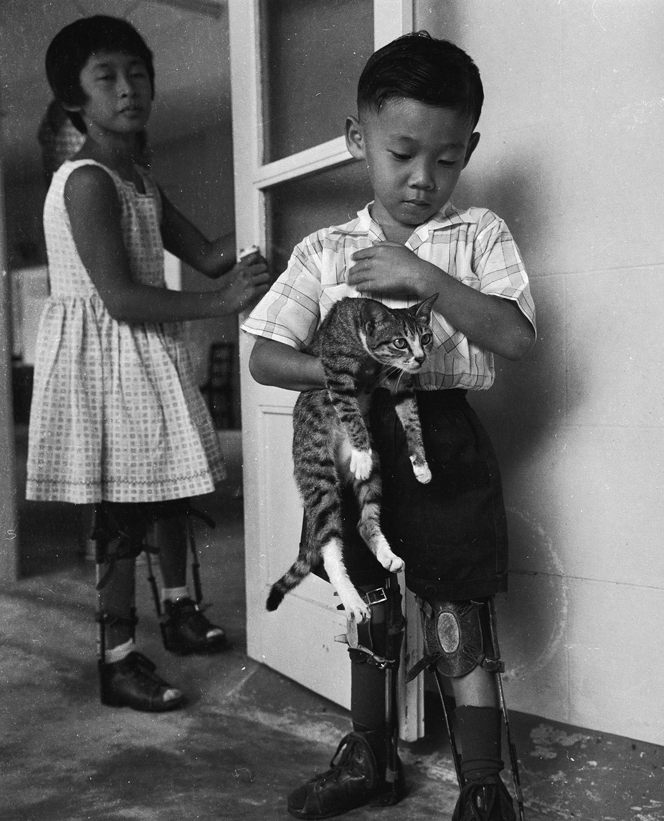 Seorang anak laki-laki korban polio mengenakan penyangga kaki.