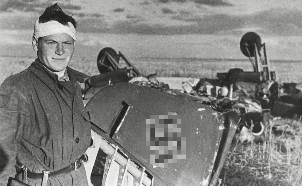 Un soldato posa vicino a un aereo nazista abbattuto
