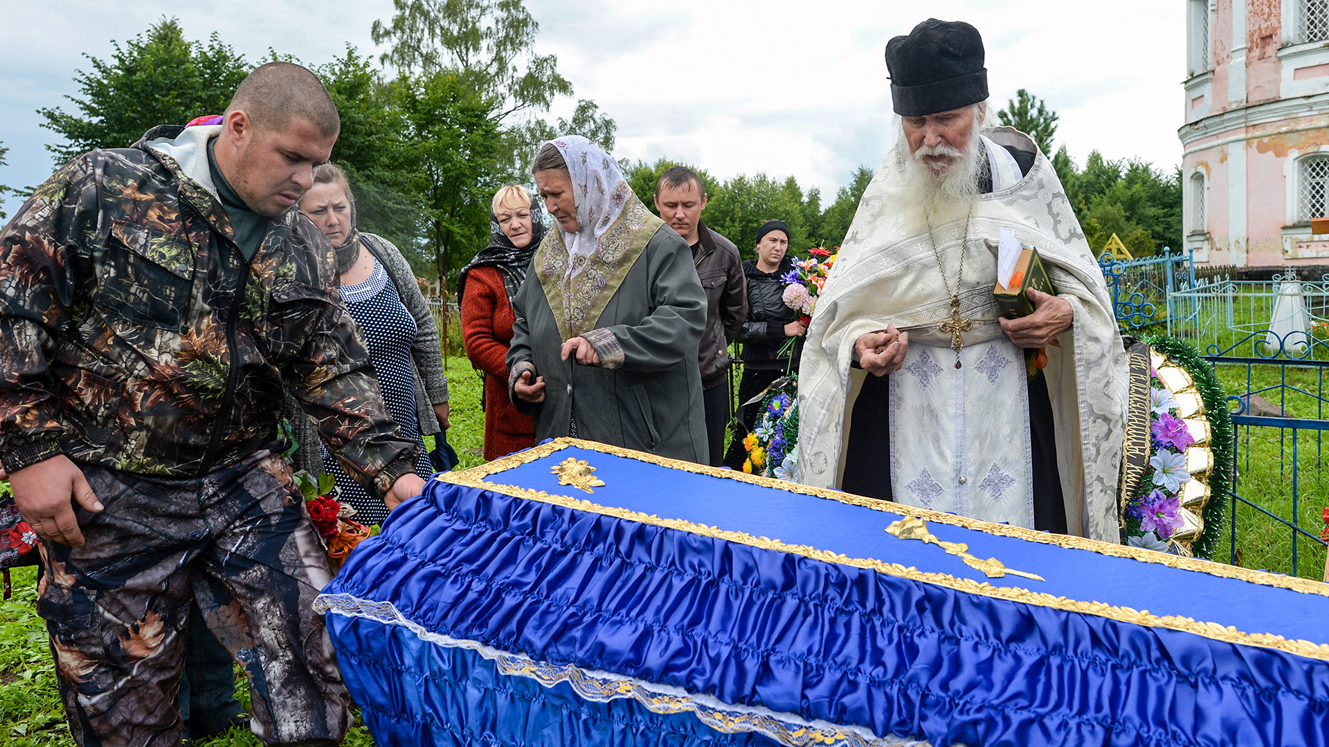 Father Sergiy, a priest and presbyter of St. Flor and St. Lavr Church in Florovskoye, Yaroslavl Region, during a funeral service at the cemetery.