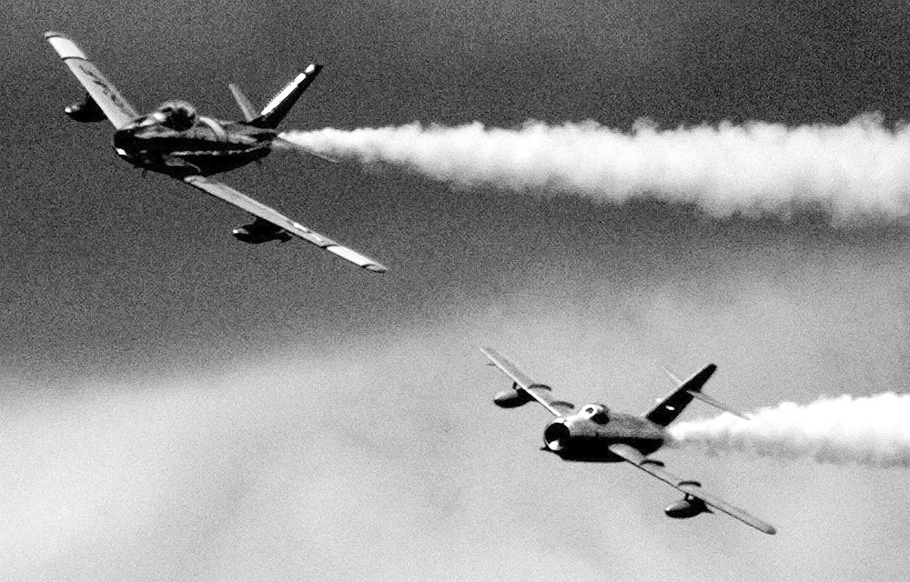 F-86 Sabre da guerra da Coreia perseguido por MiG-15.