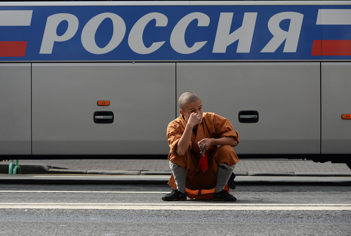 Ein chinesischer Musiker (aus dem Shaolin-Kloster) sitzt in der Hocke und wartet darauf, dass er während des Musikfestivals „Spasskaja Turm“ in Moskau an die Reihe kommt