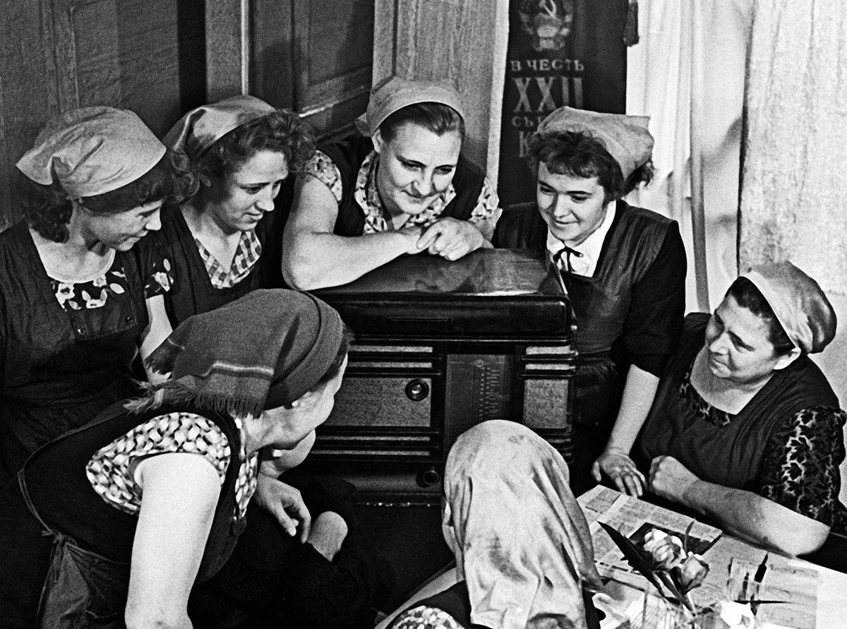 Lavoratori di una fabbrica di abbigliamento ascoltano un servizio radiofonico sul volo di Gagarin
