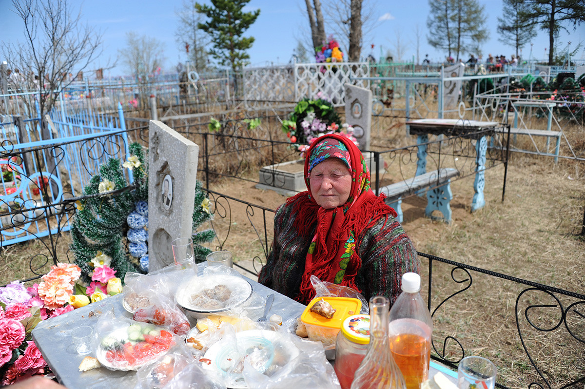 Seorang wanita tengah berziarah di pemakaman Desa Novotroitsk, Zabaykalsky Krai, pada Hari Peringatan (Radonitsa).
