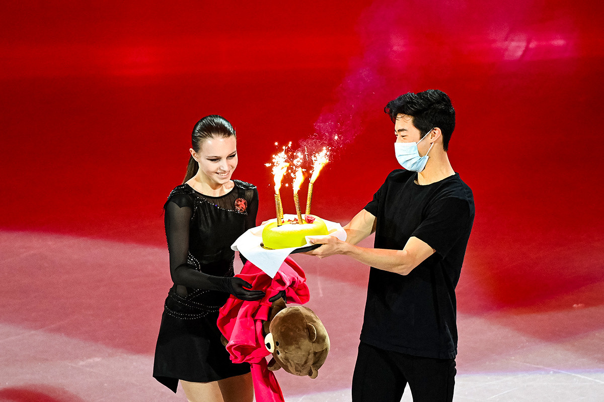 US' Nathan Chen (R) gives a birthday cake to Russia's Anna Shcherbakova for her 17th birthday during the Gala Exhibition event of the ISU World Figure Skating Championships in Stockholm on March 28, 2021
