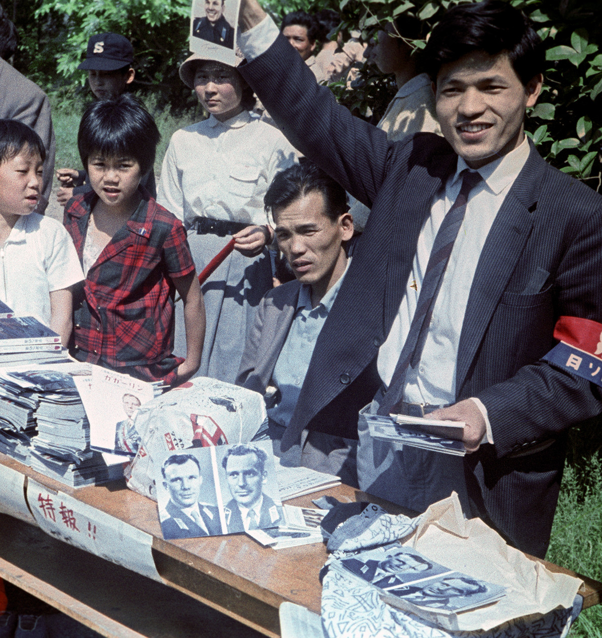 ガガーリンを歓迎する東京の人々。集まった人々にソ連初の宇宙飛行士であるユーリー・ガガーリンとゲルマン・チトフの写真を配るボランティアスタッフ
