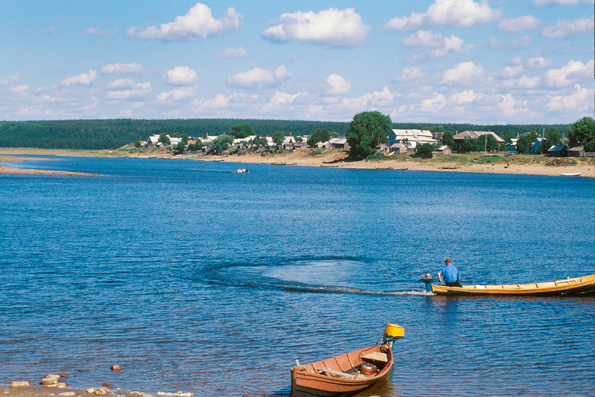 Vue sur la rive gauche de la rivière Varzouga. Les embarcations en bois servent à traverser la rivière
