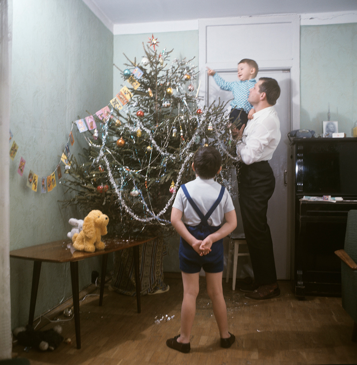 Una famiglia addobba l'albero di Capodanno