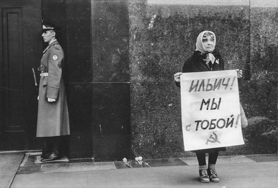 Une femme lors d'un rassemblement près du mausolée de Lénine. L’affiche dit : « Ilitch [Lénine], nous sommes avec toi ! ».