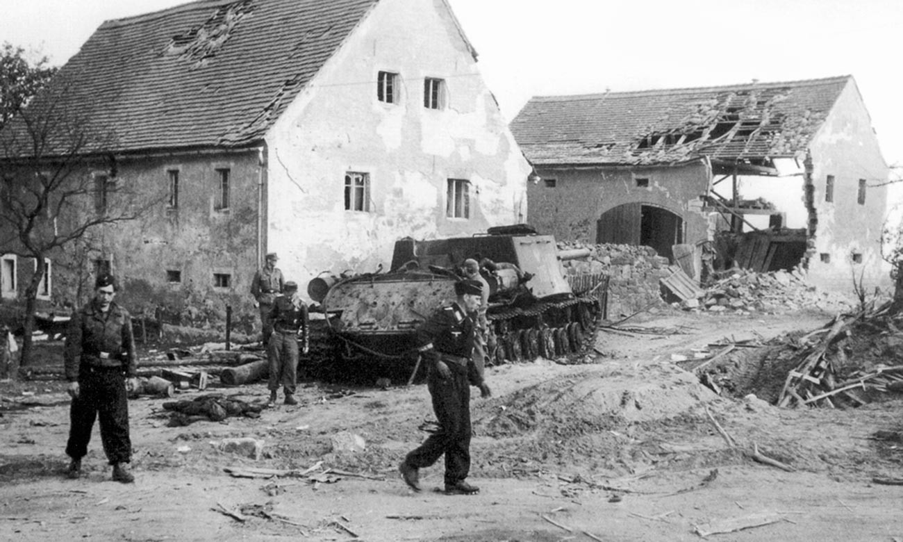 Nemški tankisti pregledujejo uničen poljski samohodni top ISU-122 v naselju blizu Bautzna.