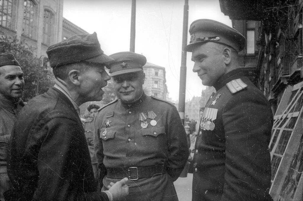 Des officiers soviétiques discutent avec des habitants de Berlin