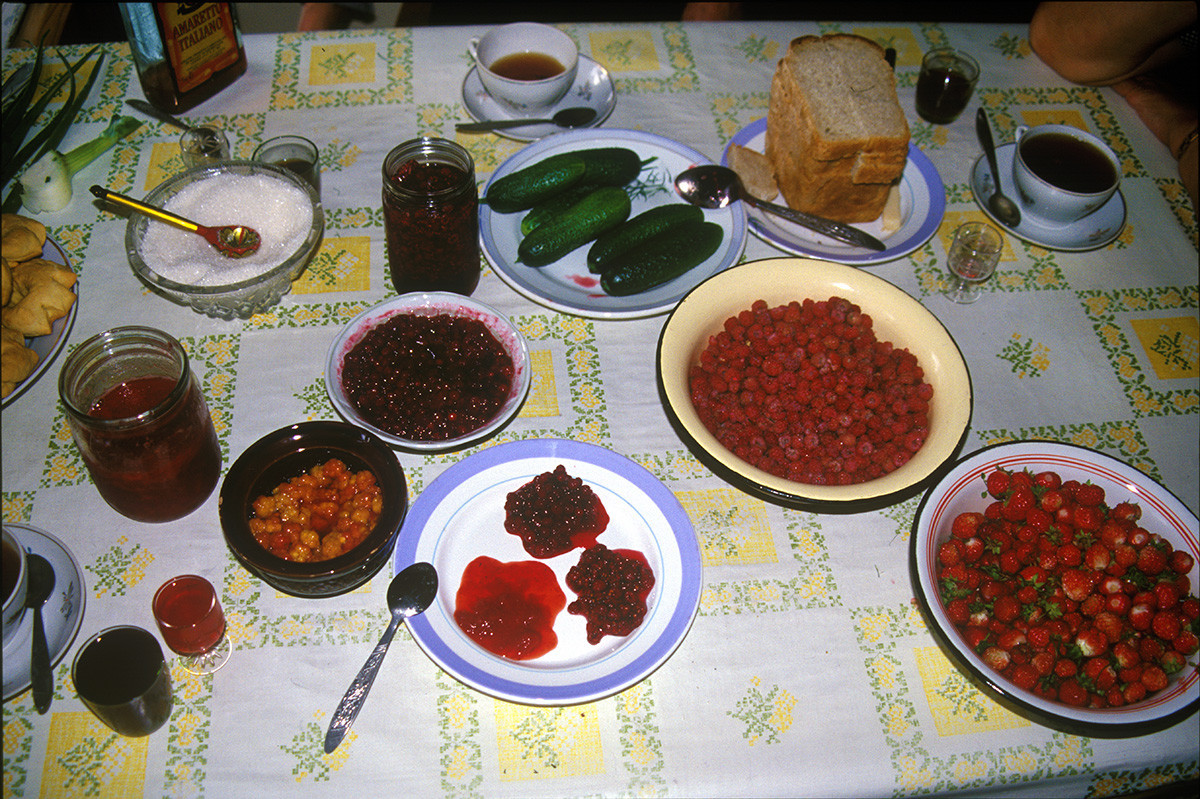 Kimža. Kuhinjska miza v hiši Lidije Ivanovne. Gozdne jagode, vrtni pridelki, marmelade, vložena zelenjava, kiselj, mors - vse so zbrali in pridelali Lidija Ivanovna in njeni prijatelji. 2. avgust 2000