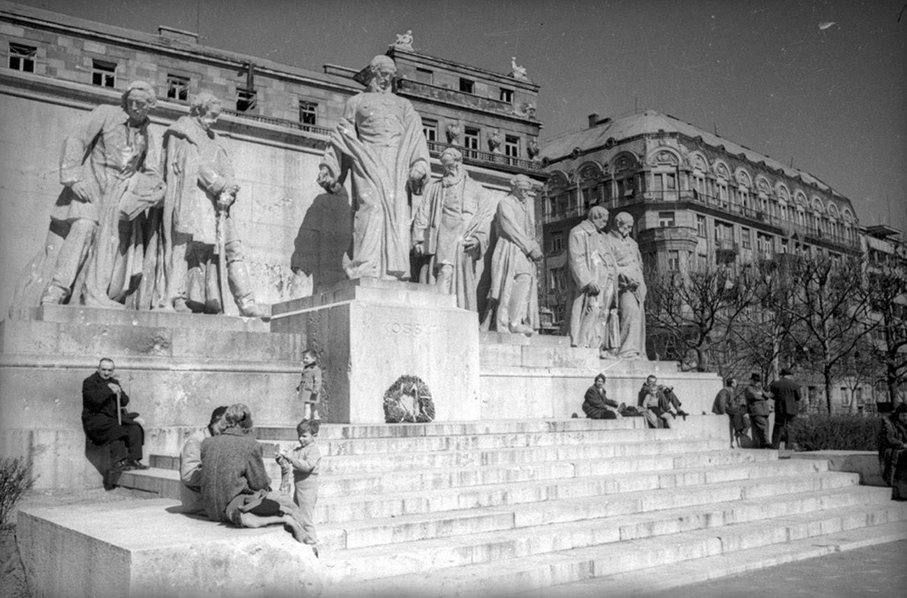 Des habitants de Budapest à côté du monument à Lajos Kossuth, président-gouverneur de Hongrie du XIXe siècle
