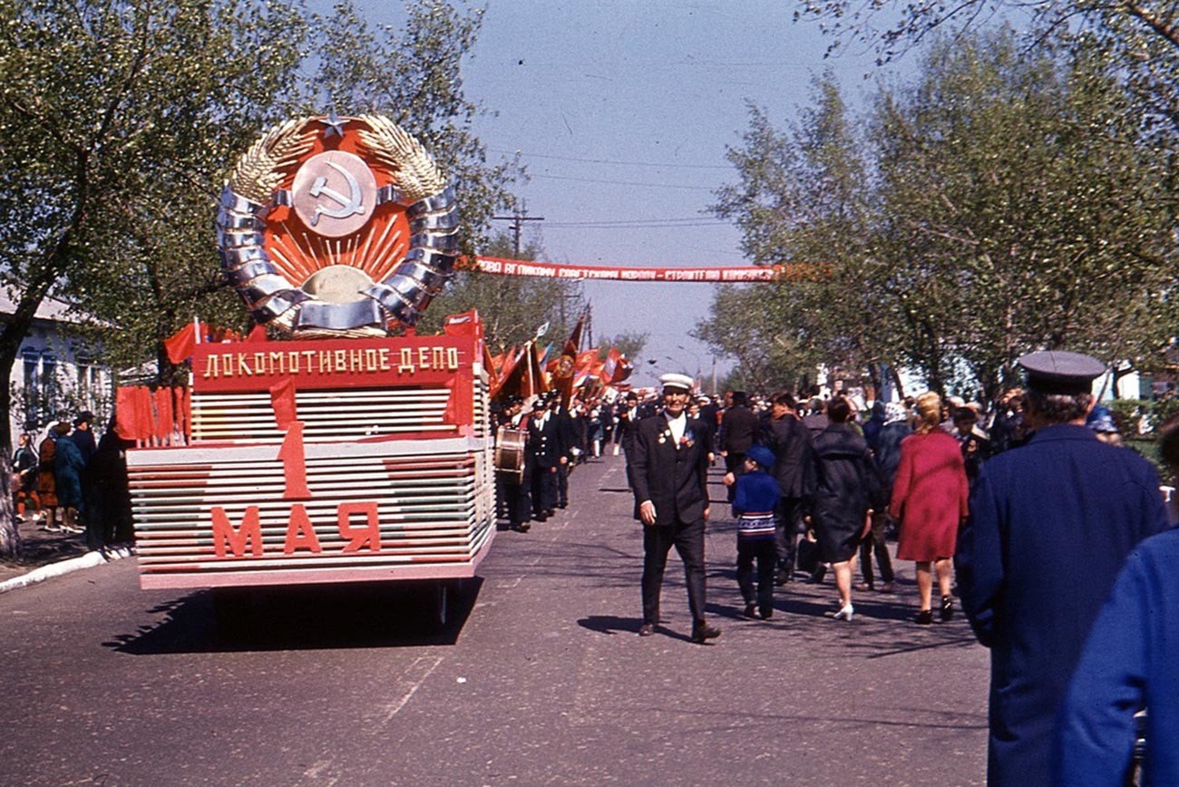 Des employés du dépôt de locomotives de la ville de Voronej marchent dans les rues avec les drapeaux rouges et des décorations, 1970
