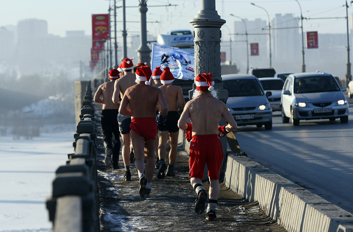 Des joggeurs en tenues de Père Noël traversent le fleuve Ob à Novossibirsk, la capitale de Sibérie
