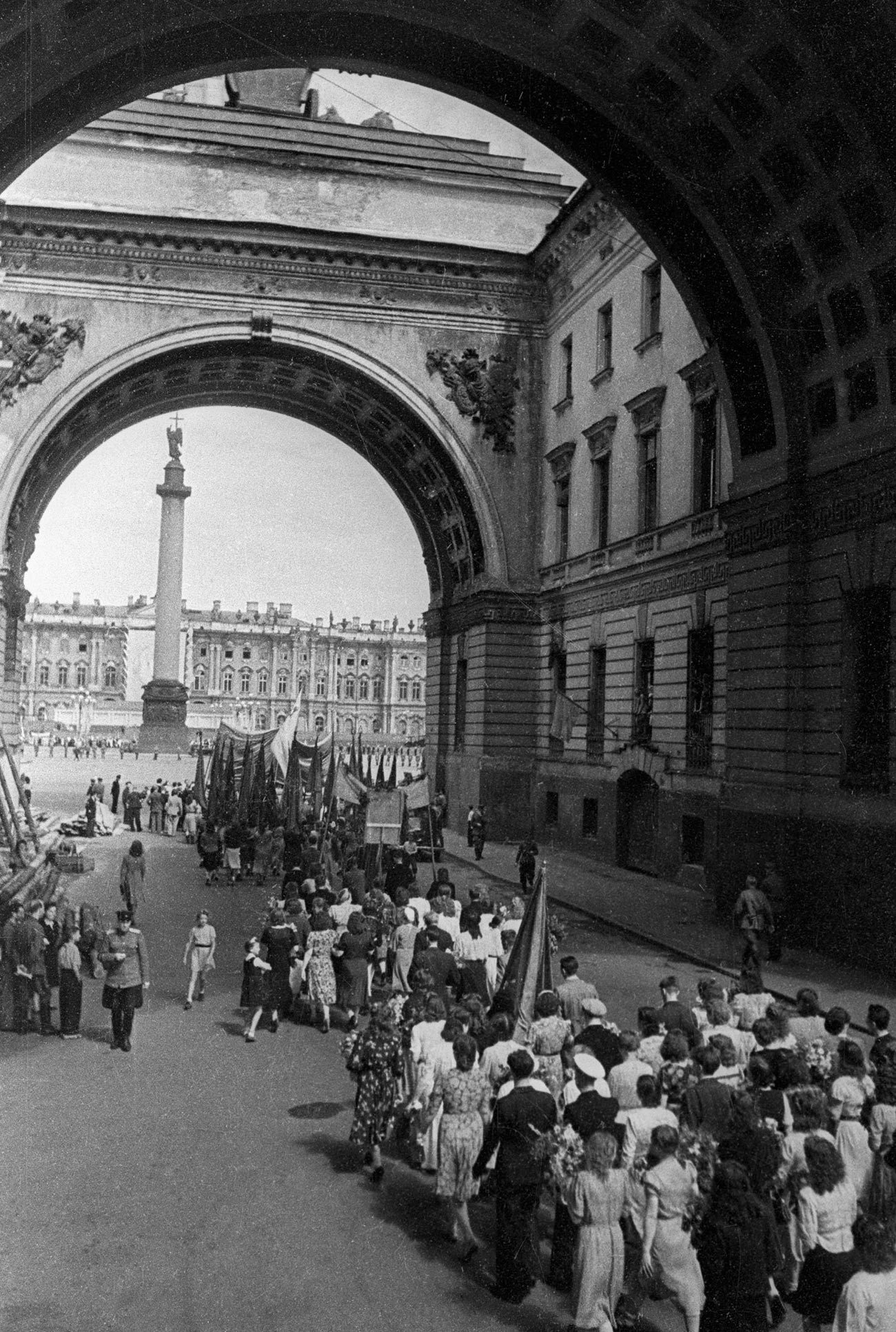 Колонна демонстрантов проходит под Триумфальной аркой главного штаба в Ленинграде.