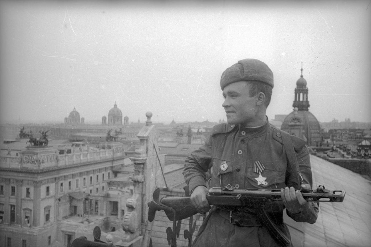 Un soldat soviétique posant sur le toit de l'un des bâtiments de la ville

